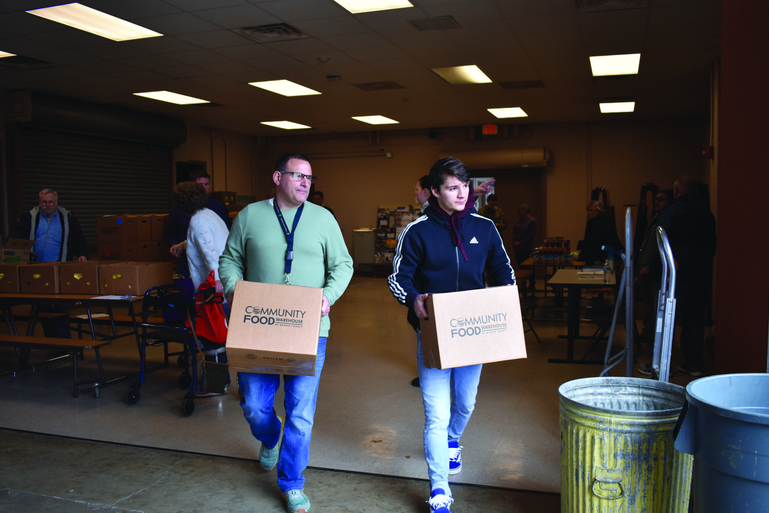 Staff and youth carrying boxes off food